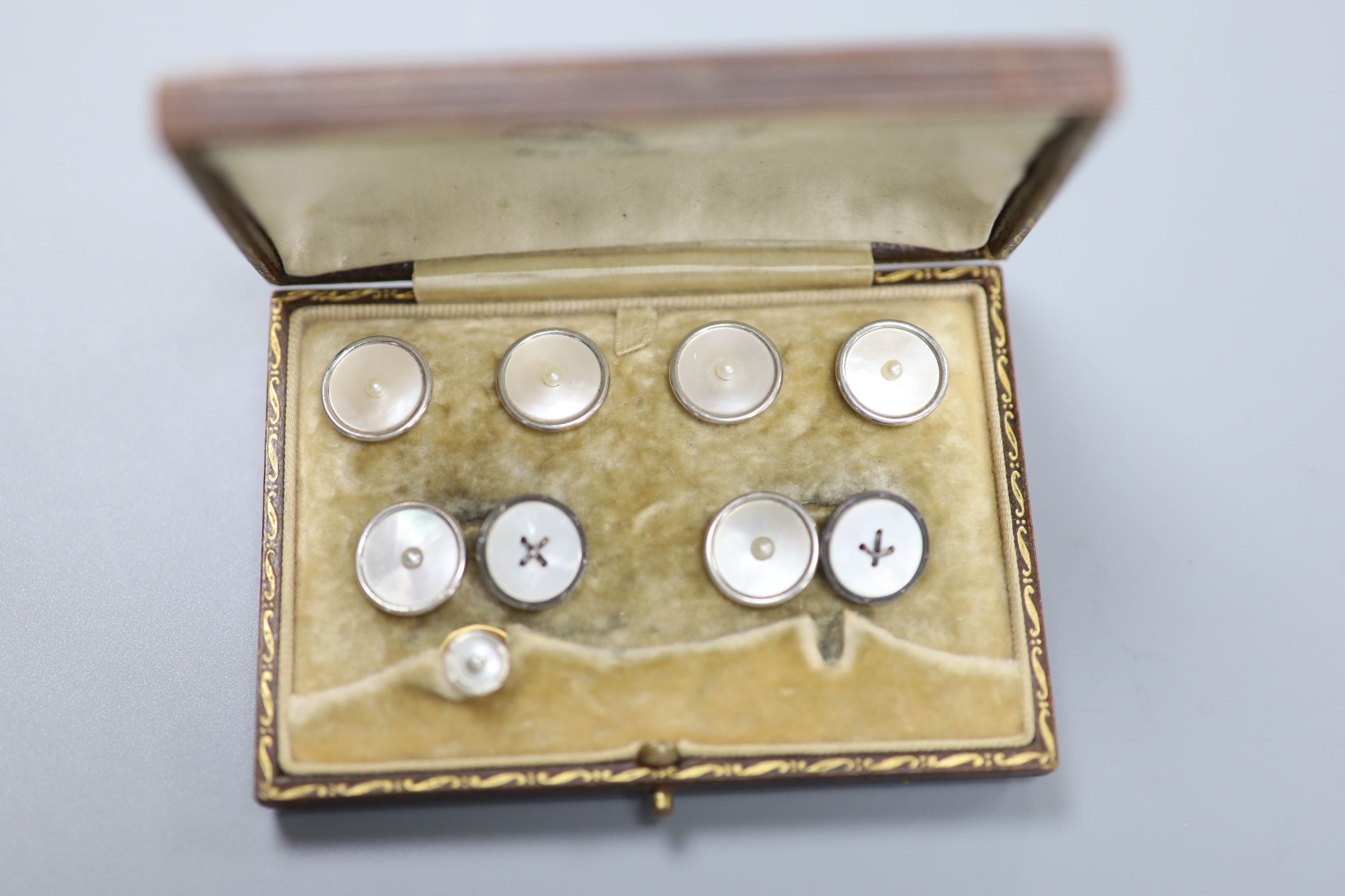 A yellow metal (stamped 18), mother of pearl and seed pearl set six piece part dress stud set and one other 18ct , mother of pearl and diamond set dress stud